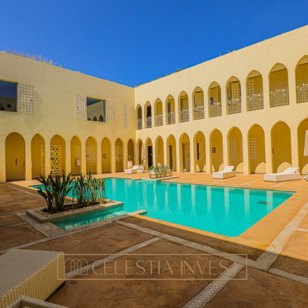 Piscine à débordement étincelante entourée de chaises longues, offrant une vue imprenable sur l'horizon marin depuis l'Hôtel Fadwa