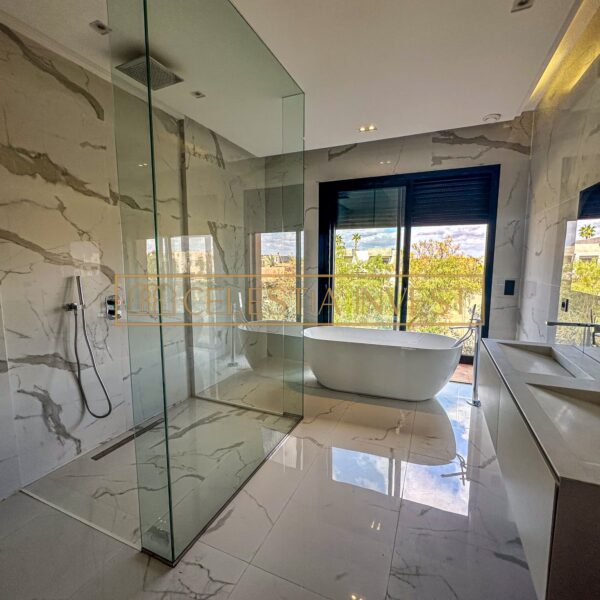 Contemporary bathroom with island bath and panoramic view.