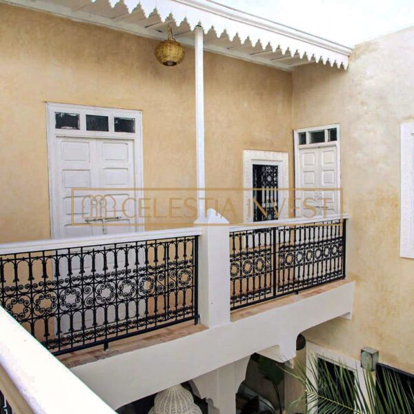 Balcón interior del Riad con paredes de tadelakt, intrincadas ventanas enrejadas y balaustrada de hierro forjado.