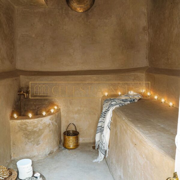 Hammam del Riad con banco tadelakt, iluminación tenue y accesorios de baño