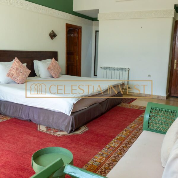 Guest room with king-size bed, traditional red carpet and Moroccan decor.