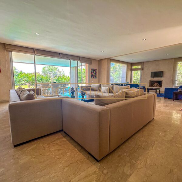 A warm and spacious living room with marble floor, fireplace and soft sofas, ideal for relaxing and entertaining guests.