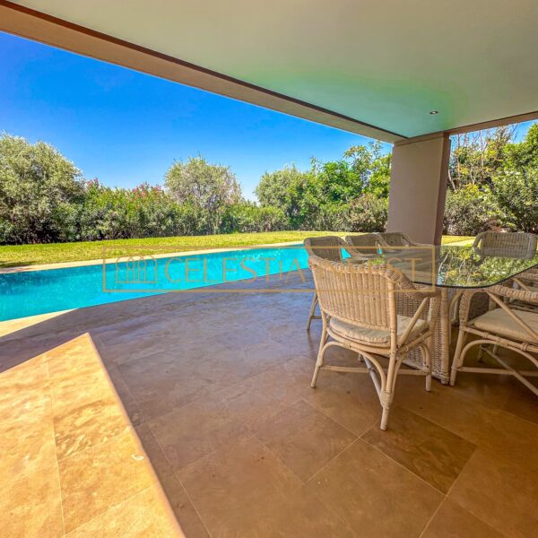 A sparkling pool surrounded by a lush patio and sun loungers, offering a refreshing oasis from the hot Moroccan sun.